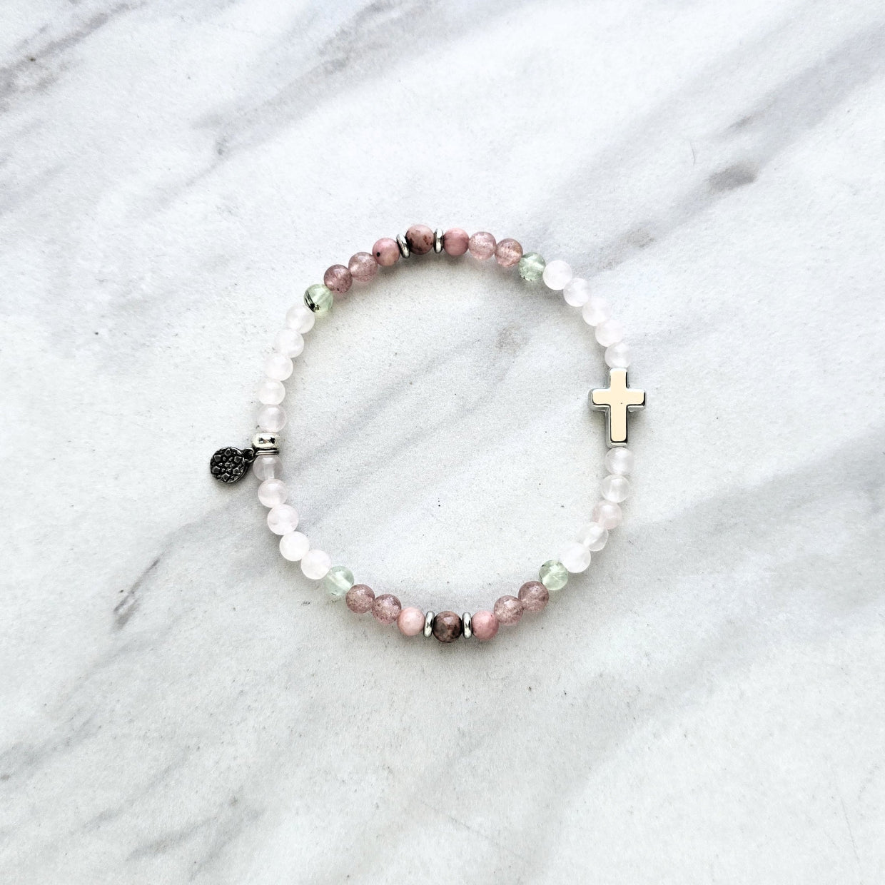 Beaded bracelet with a silver cross charm on a marble surface, featuring John 3:16 Christian bracelet love