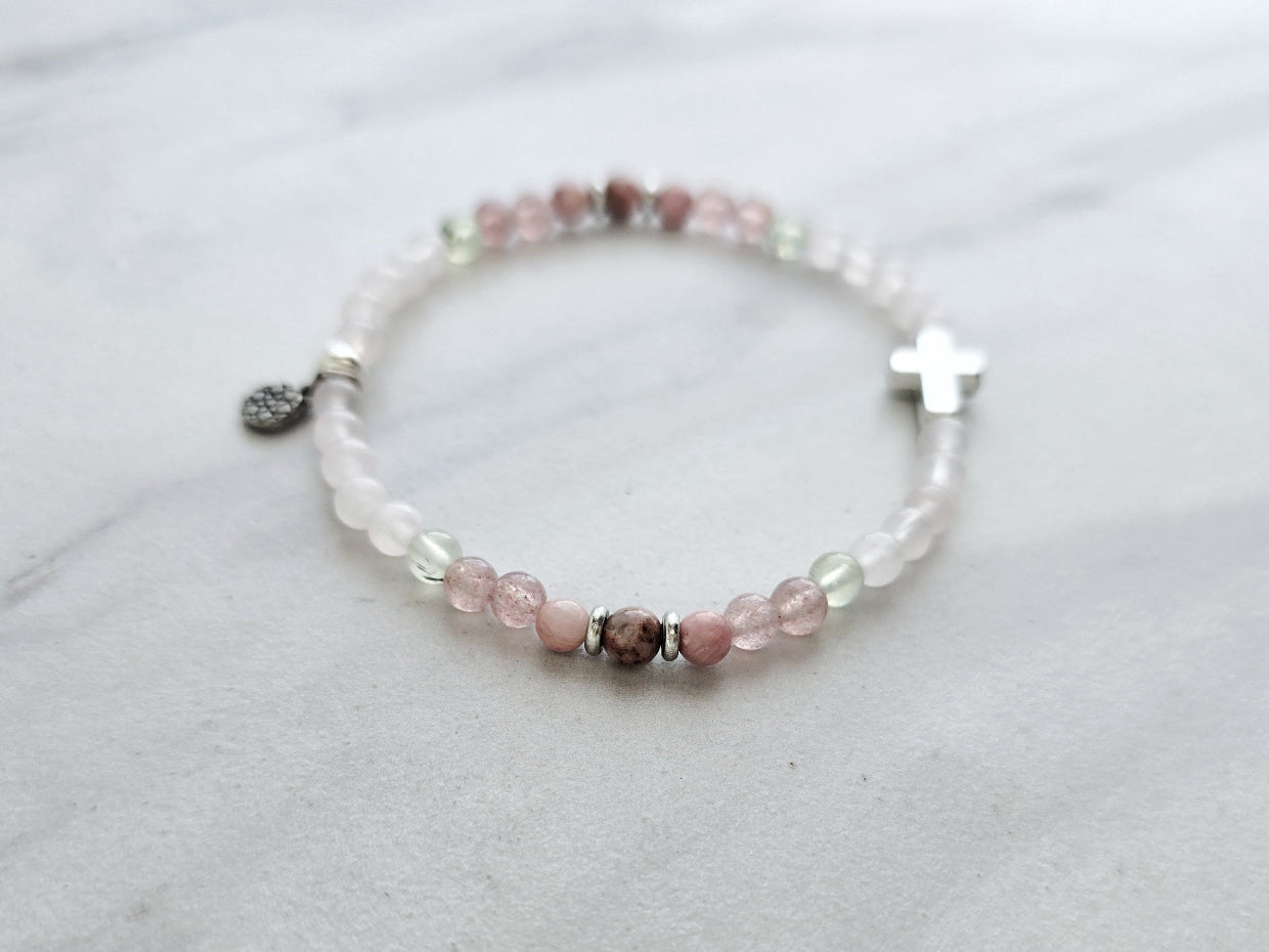 Beaded bracelet with a silver cross charm on a marble surface, featuring John 3:16 Christian bracelet love