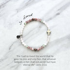 Beaded bracelet with a silver cross charm on a marble surface, featuring John 3:16 Christian bracelet love