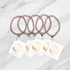 Two strawberry quartz beaded bracelets with matching tags on a marble surface. valentines day galentines gifts