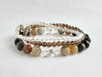Set of beaded bracelets with clear, brown, and black beads on a light gray background
