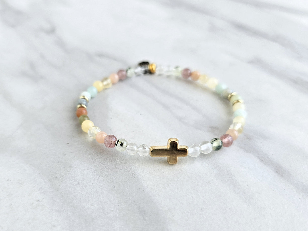 Beaded bracelet with a gold cross charm on a marble surface, featuring a religious quote. psalms 139:13-14 Christian bracelet wonderfully made