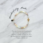 Beaded bracelet with a cross charm on a marble surface, featuring a religious quote. psalms 139:13-14 Christian bracelet wonderfully made